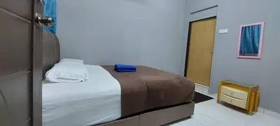 a bedroom with a bed with a blue towel on it at Sobey Laris Roomstay GUA MUSANG in Gua Musang