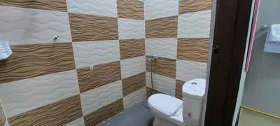 a bathroom with a toilet and a wall at Sobey Laris Roomstay GUA MUSANG in Gua Musang