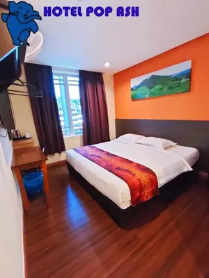 a hotel room with a bed and a television at HOTEL POP ASH in Brinchang