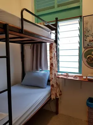 a bunk bed in a room with a window at Sojourn Beds & Cafe in Taiping