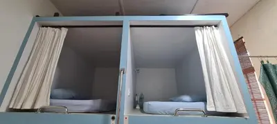 two beds in a room with glass doors at Sojourn Beds & Cafe in Taiping