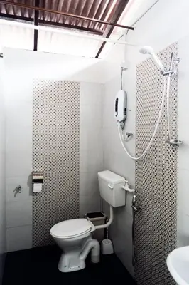 a bathroom with a toilet and a shower and a sink at Sojourn Beds & Cafe in Taiping