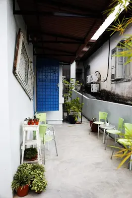 a patio with a table and chairs and plants at Sojourn Beds & Cafe in Taiping