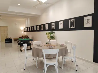 a dining room with a table with white chairs and a table and a table at Sunway Tambun Salesman Stay 5 Bedroom 10pax by IWH in Ipoh