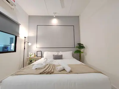 a bedroom with a large white bed with two towels on it at Sunway Tambun Salesman Stay 5 Bedroom 10pax by IWH in Ipoh