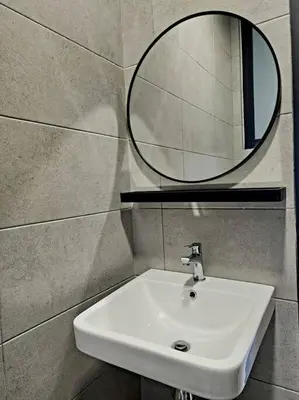 a bathroom with a white sink and a mirror at Modern Luxe Island Suites #3BR in Jelutong