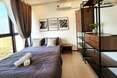 a bedroom with a bed and a dresser at Modern Luxe Island Suites #3BR in Jelutong