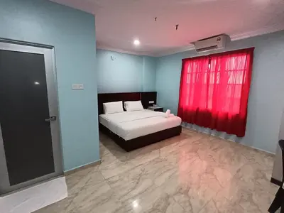a bedroom with a bed and a red window at river hotel in Simpang