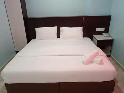 a bed with a pink object on top of it at river hotel in Simpang
