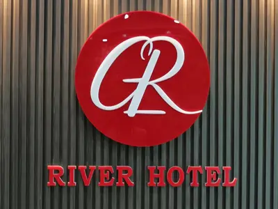 a red sign for a river hotel on a wall at river hotel in Simpang