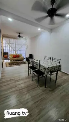 a living room with a table and chairs and a ceiling fan at Homestay Mukhriz in Kulim