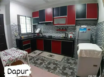 a kitchen with red and black cabinets and a refrigerator at Homestay Mukhriz in Kulim