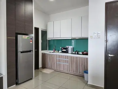a kitchen with white cabinets and a stainless steel refrigerator at THE MAJESTIC IPOH A20 by ZamanJa in Ipoh