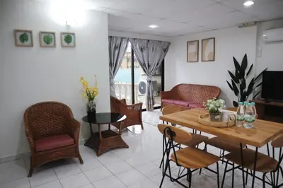 a living room with a table and chairs at Jo Jo Homestay @ Pangkor Coral Bay Resort in Pasir Bogak