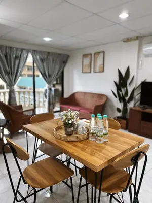 a wooden table with chairs and bottles on it at Jo Jo Homestay @ Pangkor Coral Bay Resort in Pasir Bogak