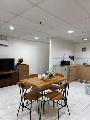 a kitchen with a wooden table and chairs at Jo Jo Homestay @ Pangkor Coral Bay Resort in Pasir Bogak