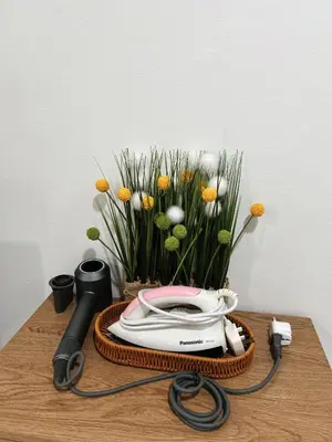 a table with a phone and a bouquet of flowers at Jo Jo Homestay @ Pangkor Coral Bay Resort in Pasir Bogak