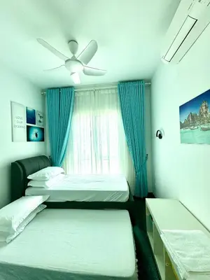 a bedroom with two beds and a ceiling fan at Livistona Luxe Apartment in Permatang Pauh