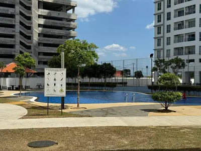 a sign in front of a pool of water with buildings at Livistona Luxe Apartment in Permatang Pauh