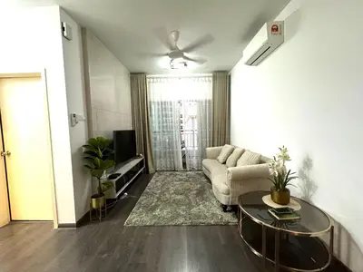 a living room with a couch and a table at Livistona Luxe Apartment in Permatang Pauh