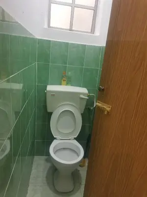 a bathroom with a toilet with a window above it at Jalinan Qaseh Homestay in Seri Manjung