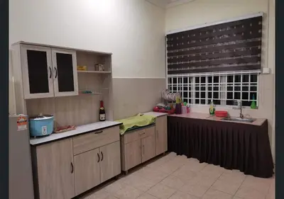 a kitchen with wooden cabinets and a sink and a window at Jalinan Qaseh Homestay in Seri Manjung
