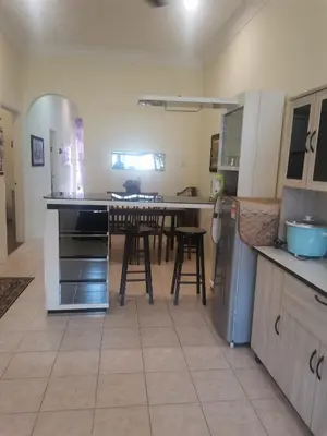 a kitchen with a table and some chairs in it at Jalinan Qaseh Homestay in Seri Manjung