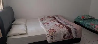 a bed with a blanket on it in a room at MAIDEEN HOMESTAY CAMERON HIGHLANDS in Brinchang