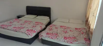 two beds sitting next to each other in a room at MAIDEEN HOMESTAY CAMERON HIGHLANDS in Brinchang