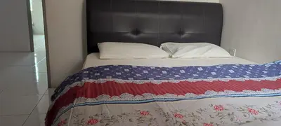 a bed with a red white and blue blanket and pillows at MAIDEEN HOMESTAY CAMERON HIGHLANDS in Brinchang