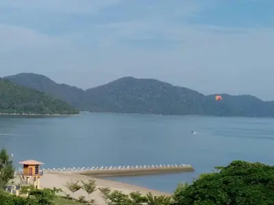 a large body of water with a pier in it at By The Sea Deluxe Condo @ Batu Ferringhi Penang in Batu Ferringhi