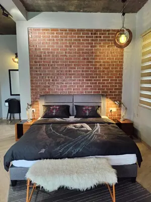 a bedroom with a brick wall and a large bed at Ipoh Eden Pool Villa Suites in Ipoh