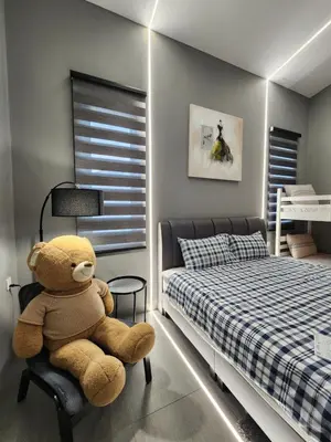a teddy bear sitting on a chair in a bedroom at Ipoh Eden Pool Villa Suites in Ipoh
