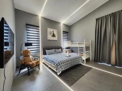 a bedroom with a bed and a teddy bear in a chair at Ipoh Eden Pool Villa Suites in Ipoh
