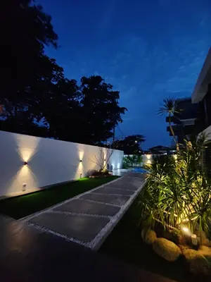 a garden at night with lights on a wall at Ipoh Eden Pool Villa Suites in Ipoh