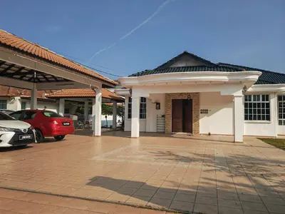 a house with a car parked in a parking lot at Padang Serai Room Stay Share Bathroom in Padang Serai