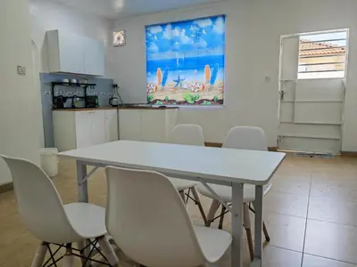 a kitchen with a white table and white chairs at Padang Serai Roomstay Family Suite Share Bathroom804 in Padang Serai