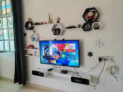 a room with a tv on a wall with shelves at Padang Serai Roomstay Family Suite Share Bathroom804 in Padang Serai