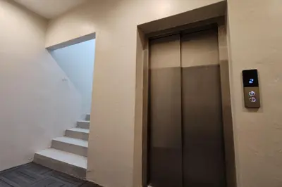 a hallway with a door and stairs in a building at Casa Colney Hotel Ipoh in Ipoh