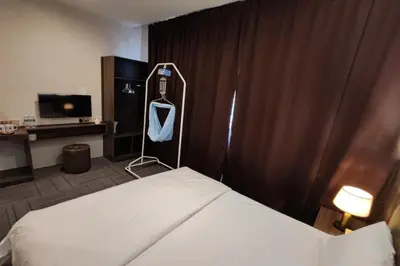 a hotel room with a bed and a curtain at Casa Colney Hotel Ipoh in Ipoh