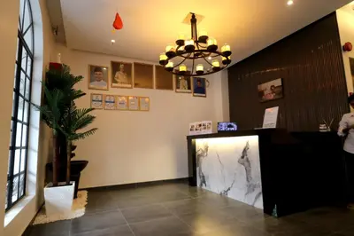 a waiting room with a counter and a chandelier at Casa Colney Hotel Ipoh in Ipoh