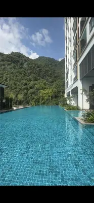 a large blue swimming pool next to a building at Doma House Onsen at Sunway Onsen, Tambun in Ipoh