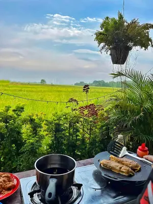 a table with a pot and some food and a field at Paddy Villea with 5 Bedrooms Penang in Permatang Pauh