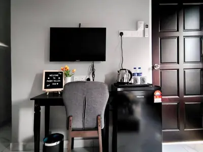 a desk with a chair and a laptop and a television at Paddy Villea with 5 Bedrooms Penang in Permatang Pauh