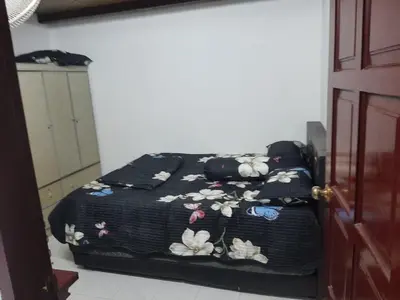 a bed with a black blanket with flowers on it at DIAMOND HOMESTAY in Kuala Kangsar