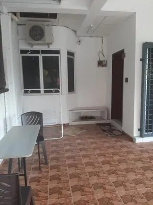 a living room with a table and chairs and a room with a fan at DIAMOND HOMESTAY in Kuala Kangsar