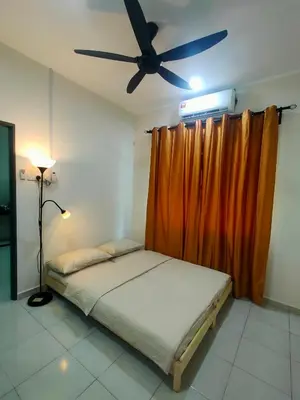 a bed in a room with a ceiling fan at Swedish Style Homestay in Teluk Intan