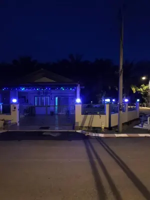 a house with blue lights in the night at Swedish Style Homestay in Teluk Intan