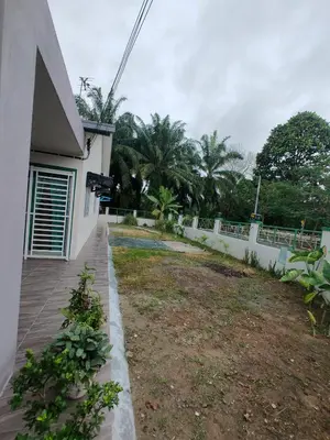 a house with a yard next to a fence at Swedish Style Homestay in Teluk Intan