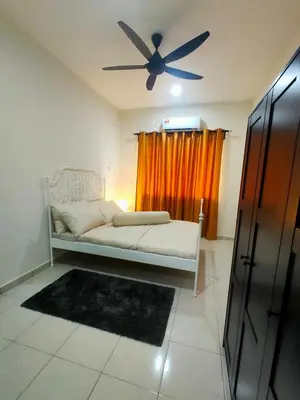 a living room with a couch and a ceiling fan at Swedish Style Homestay in Teluk Intan